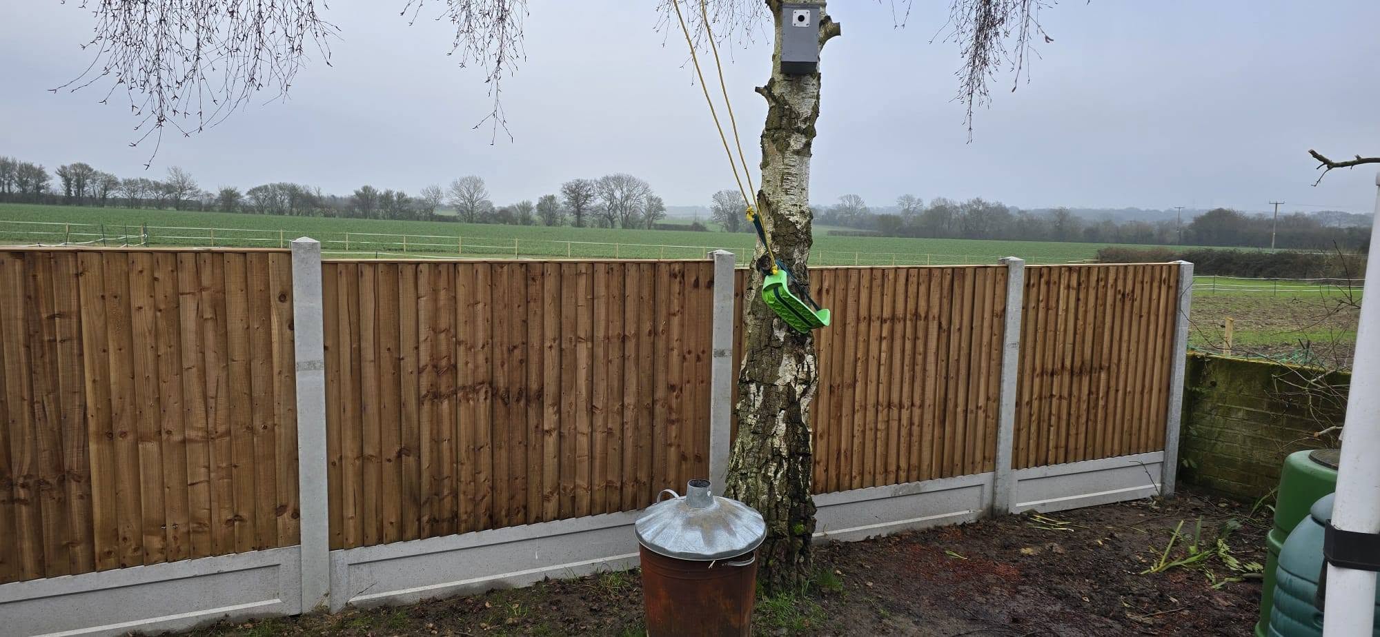 Closeboard fence run beside an open field