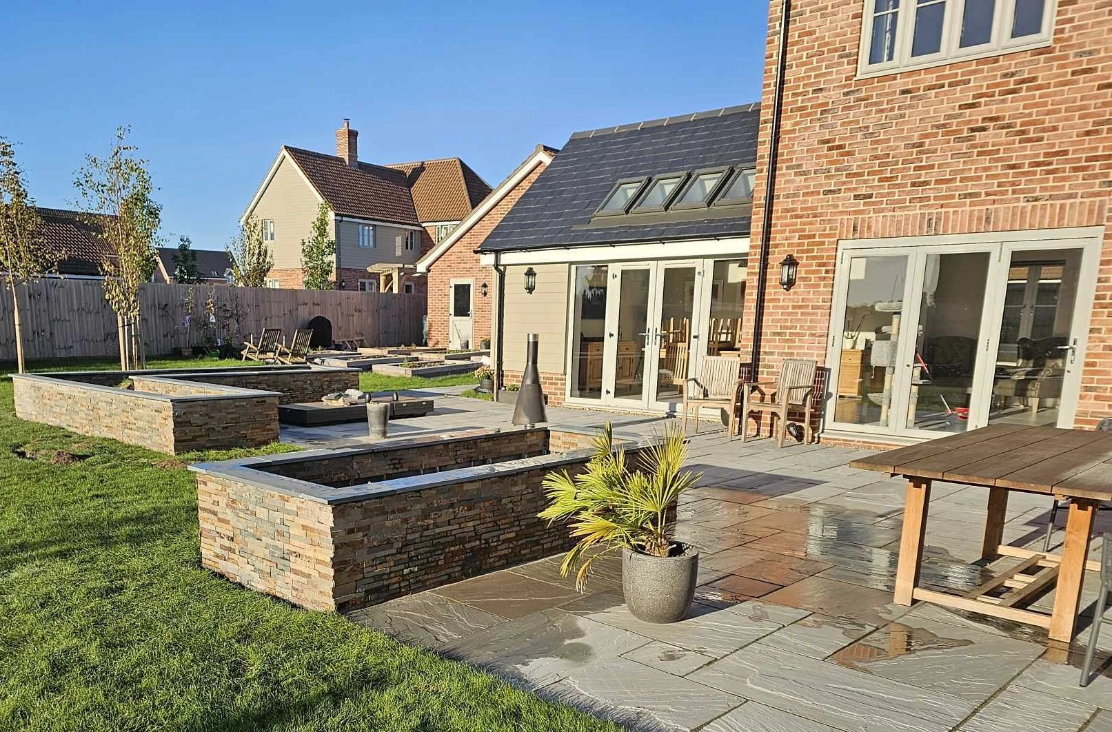 Garden with raised stone beds and a paved seating area