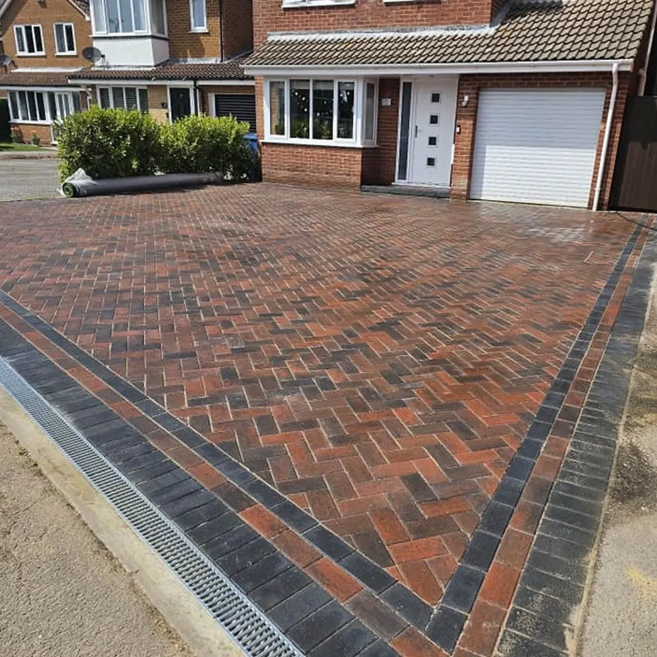 Red herringbone block paved driveway with charcoal border