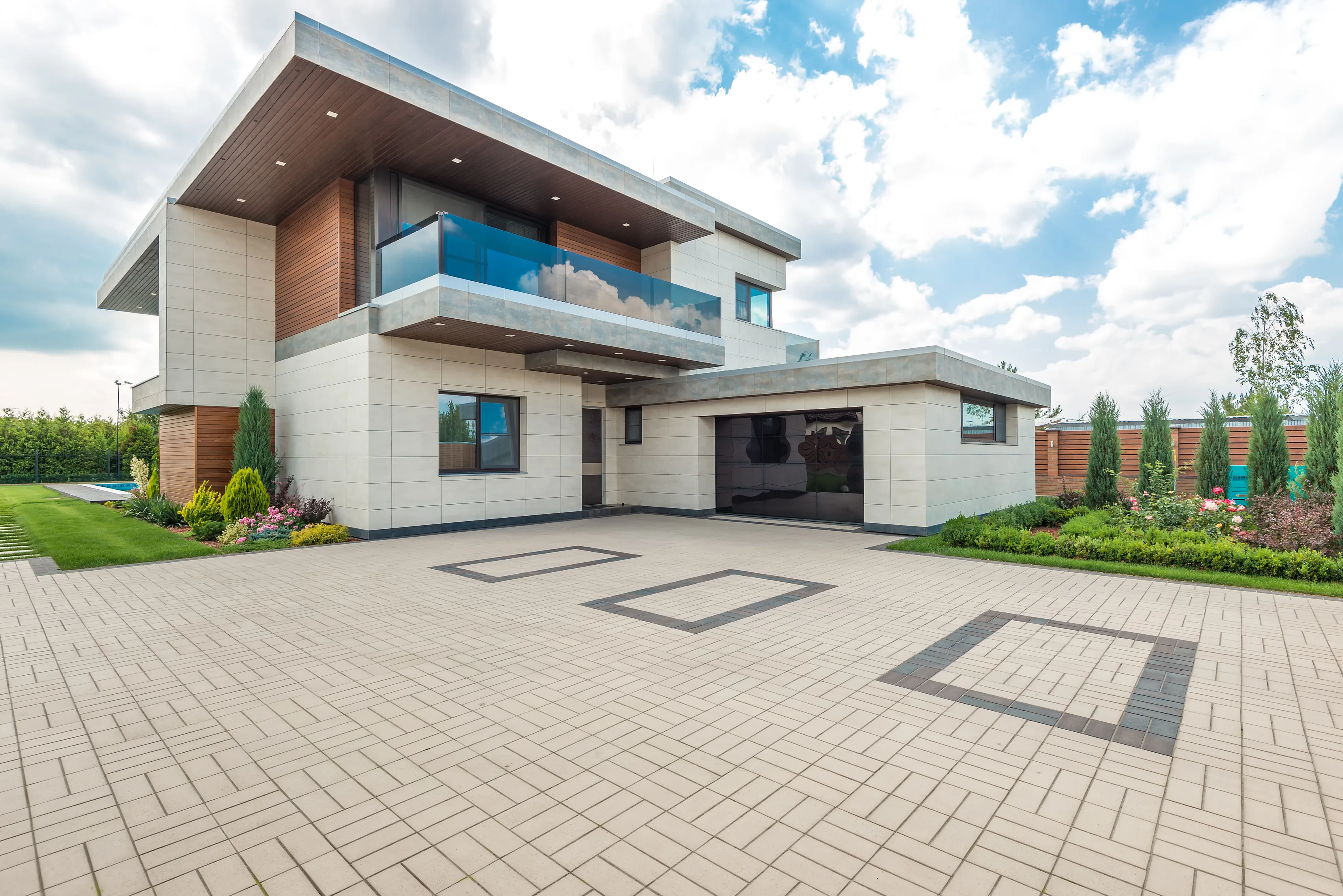 Wide block paved driveway with charcoal banding at a modern house